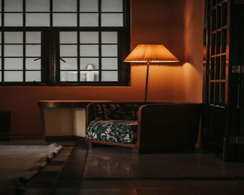Cozy reading corner in a living room with smooth diffuse lighting from a floor lamp next to a fabric armchair